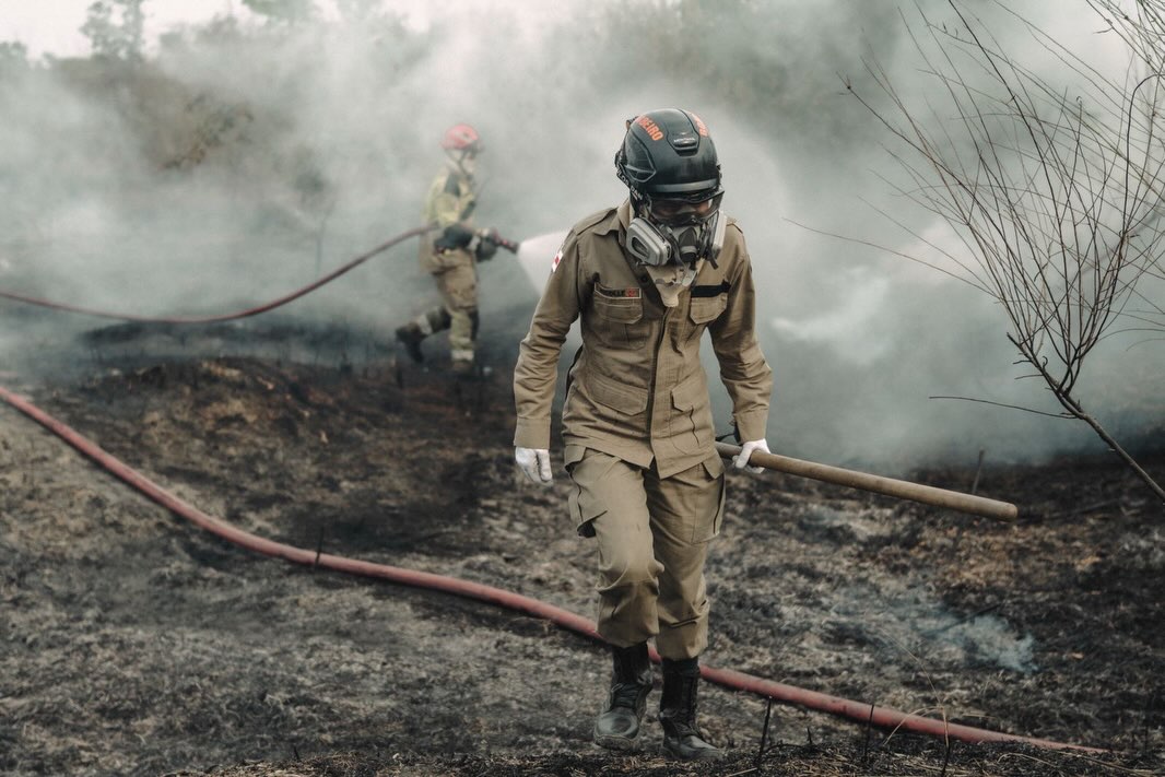 Equipe de combate ao fogo atua em meio à fumaça.